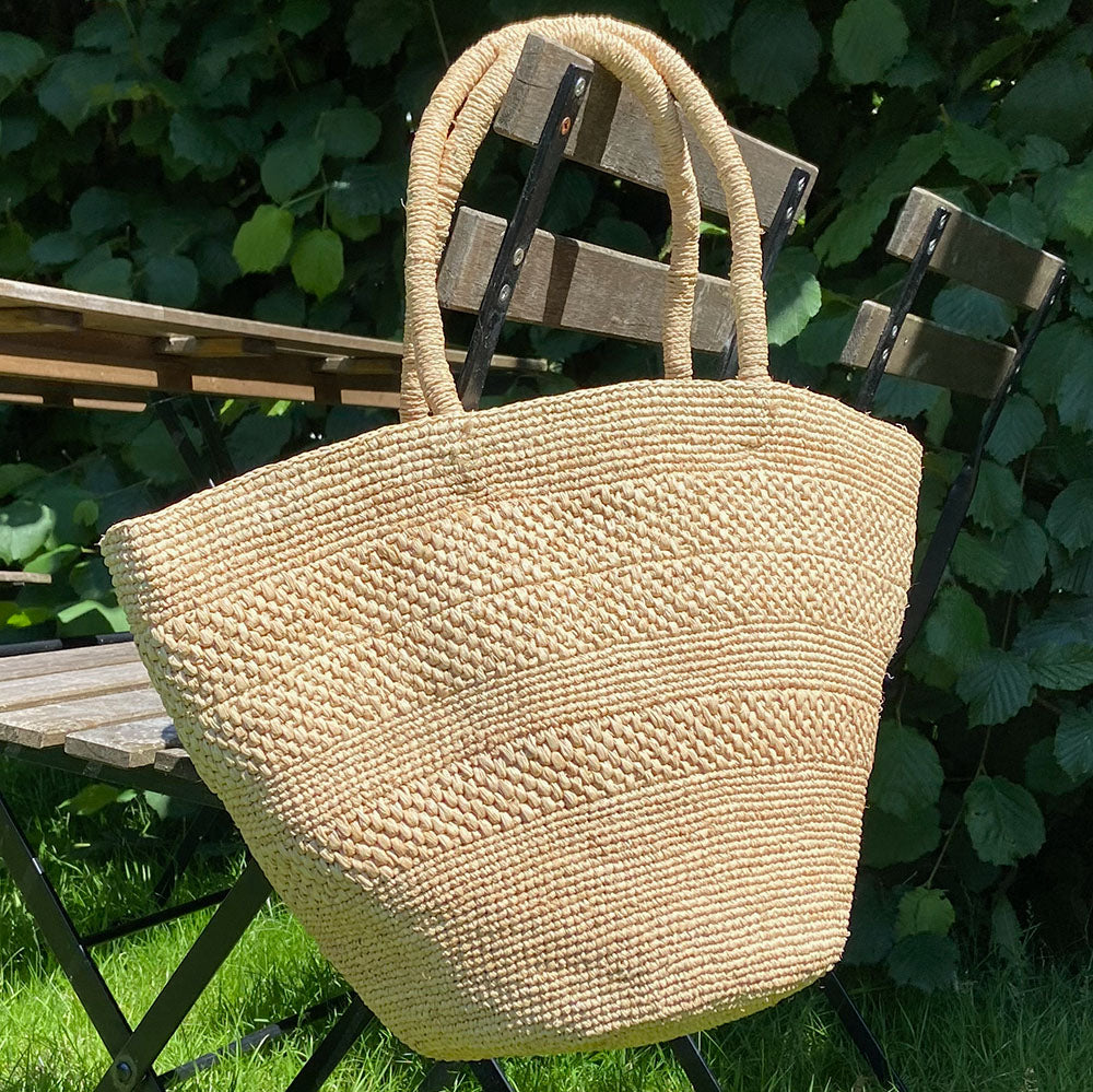Anakao, the charming bag fashioned from luxurious raffia sourced from Madagascar.  Tailored for your everyday adventures, this tote boasts a spacious main compartment to accommodate all your necessities while you're on the move.  Raffia, derived from the resilient leaves of the palm tree, is celebrated for its versatility and eco-conscious qualities, making it a sought-after material in the realm of fashion accessories. Lovelies Studio