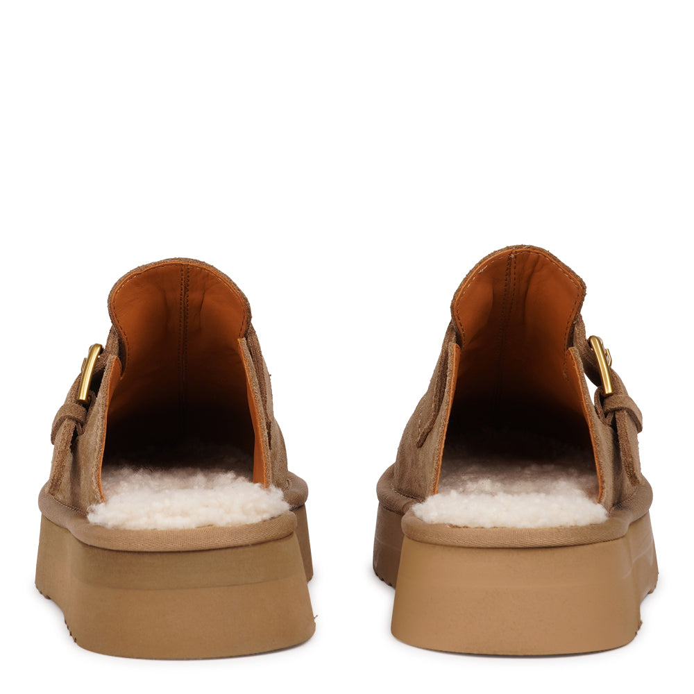 Lovelies Studio - Kokubo – Suede Mules with Adjustable Buckle
Meet Kokubo — a pair of mules that redefine everyday comfort with understated elegance. What makes them special is the plush shearling insole that gently cushions your feet, offering natural warmth and luxurious softness, even on a cold days.
Crafted from premium suede and finished with a durable rubber sole, the Kokubo mules combine style, comfort, and longevity in one effortless design.