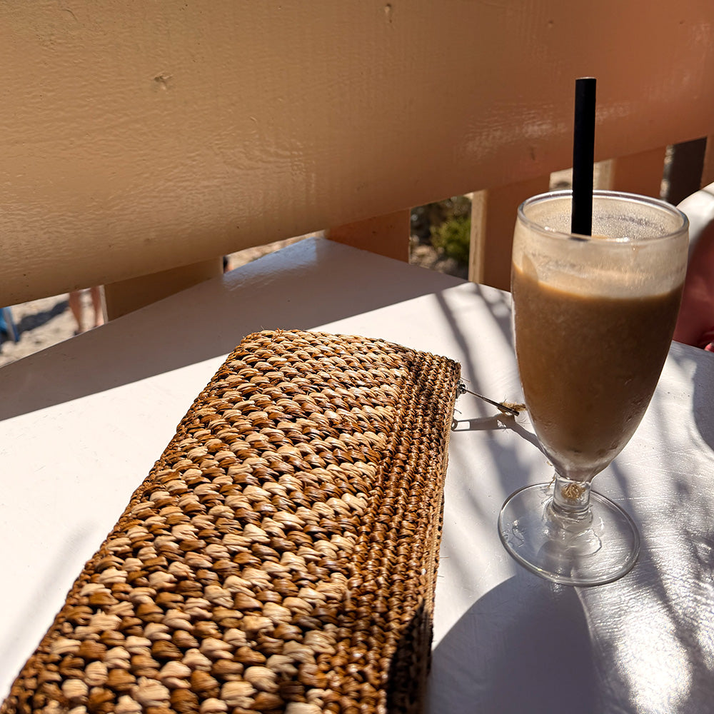 Lovelies Studio - Mimose, the little charming clutch fashioned from luxurious raffia sourced from Madagascar. Raffia, derived from the resilient leaves of the palm tree, is celebrated for its versatility and eco-conscious qualities, making it a sought-after material in the realm of fashion accessories.