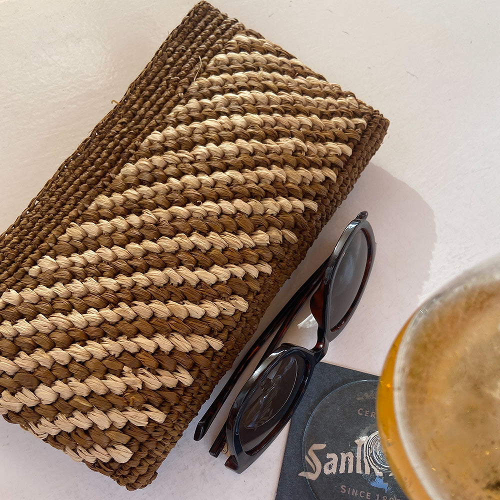 Lovelies Studio - Mimose, the little charming clutch fashioned from luxurious raffia sourced from Madagascar.  Raffia, derived from the resilient leaves of the palm tree, is celebrated for its versatility and eco-conscious qualities, making it a sought-after material in the realm of fashion accessories.