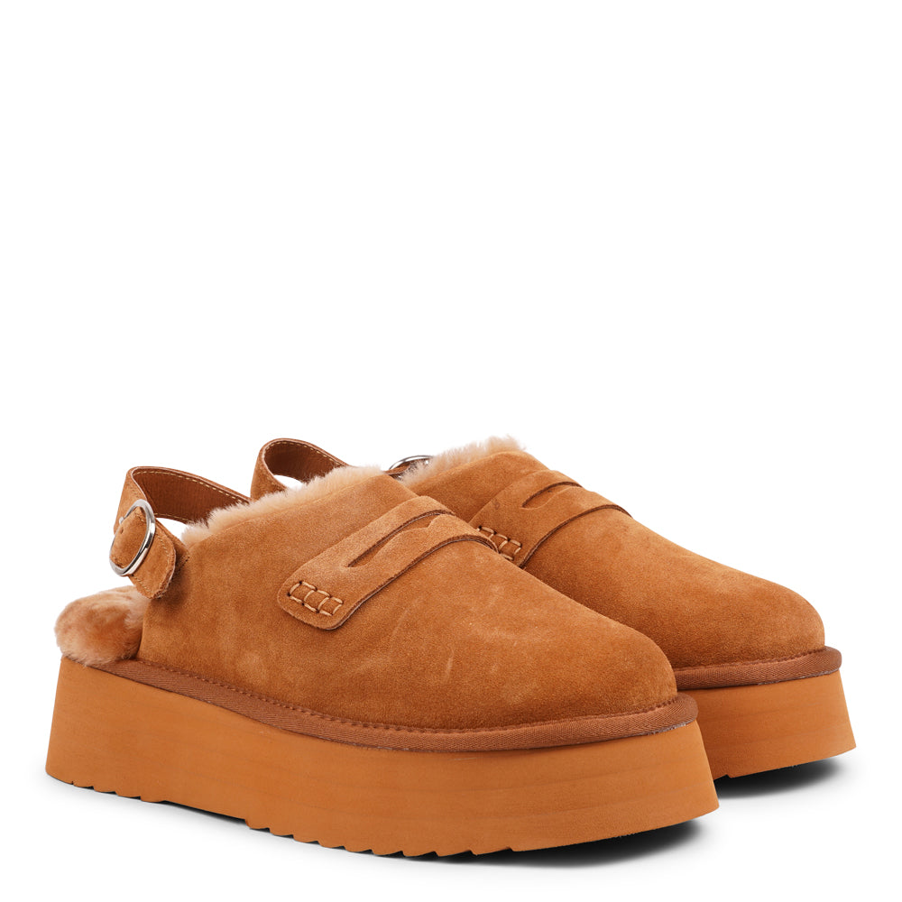 Step into a world of luxury and coziness with our Siple suede mules. Crafted with the finest suede, these mules are designed to provide not only elegance but also ultimate comfort for your feet. The sumptuous shearling lining ensures your feet stay warm and snug, making them the perfect choice for colder days.  The standout feature of the Siple mules is the adjustable heel strap, allowing you to customize the fit to your liking.