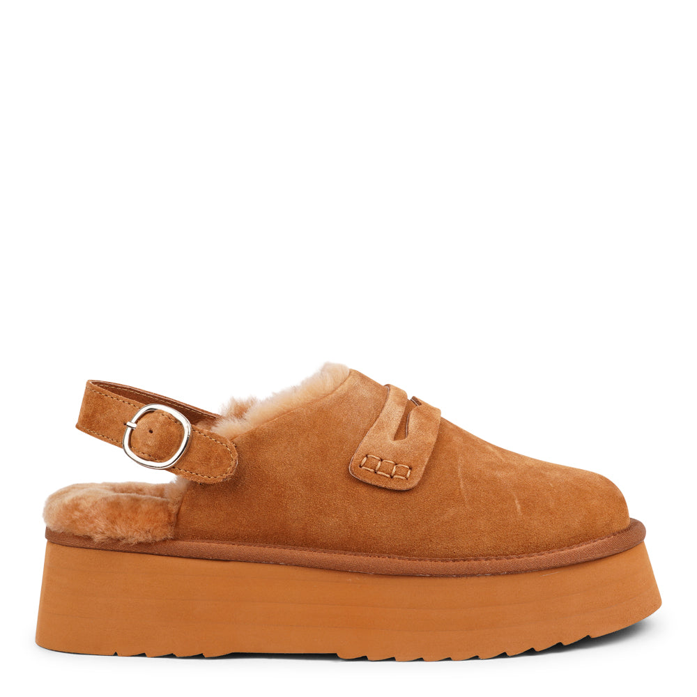 Step into a world of luxury and coziness with our Siple suede mules. Crafted with the finest suede, these mules are designed to provide not only elegance but also ultimate comfort for your feet. The sumptuous shearling lining ensures your feet stay warm and snug, making them the perfect choice for colder days.  The standout feature of the Siple mules is the adjustable heel strap, allowing you to customize the fit to your liking.
