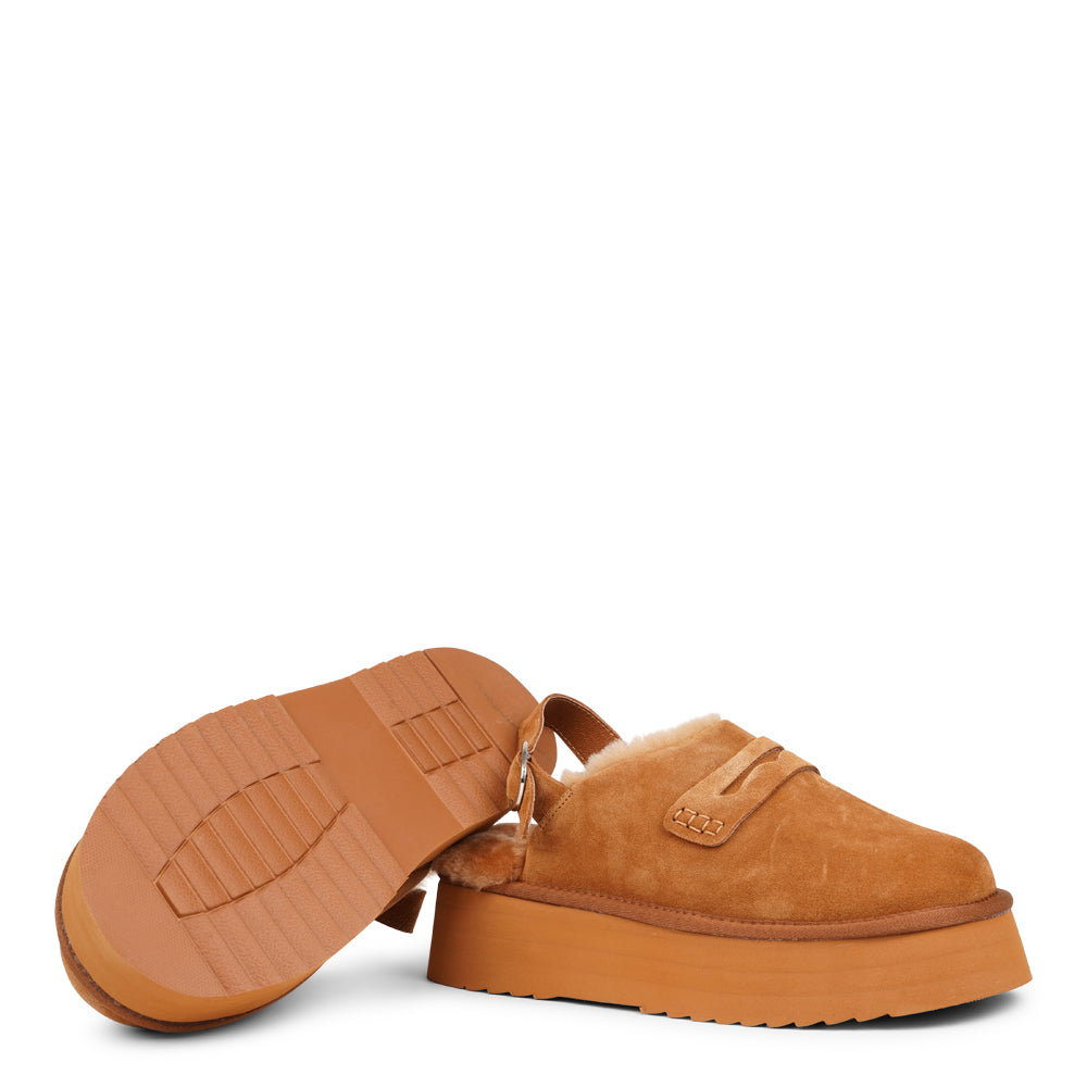 Step into a world of luxury and coziness with our Siple suede mules. Crafted with the finest suede, these mules are designed to provide not only elegance but also ultimate comfort for your feet. The sumptuous shearling lining ensures your feet stay warm and snug, making them the perfect choice for colder days.  The standout feature of the Siple mules is the adjustable heel strap, allowing you to customize the fit to your liking.