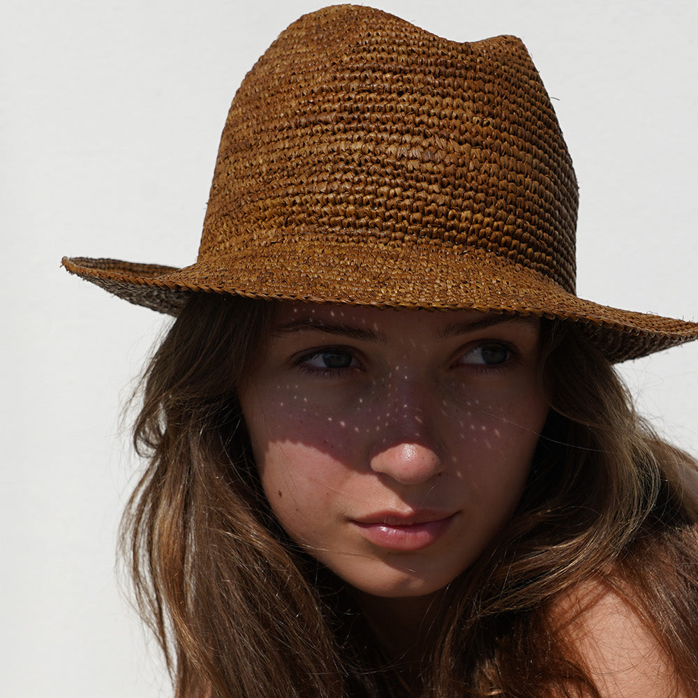 The Summery Viviani hat, a stunning creation meticulously crafted by local artisans in Madagascar exclusively for Lovelies Studio. Each piece is a testament to the skill and dedication of these artisans, who handcraft every detail with precision and care.
Made from raffia, a natural fiber renowned for its durability and flexibility, the Viviani hat is not only stylish but also eco-friendly. The raffia is carefully colored by hand using traditional methods and left to dry naturally in the warm sun