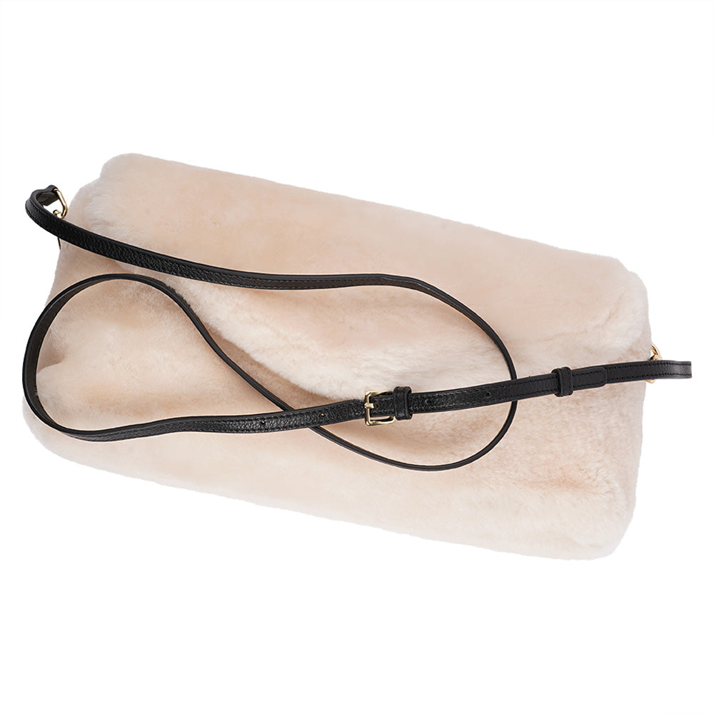 Understated and elegant, this Cona shearling clutch with detachable crossbody strap comes in both black and cream. Cona is perfect for carrying your essentials with you for party or everyday use. Front flap with hidden magnetic fastening Adjustable and detachable wrist strap Adjustable and detachable shoulder strap in leather Shoulder strap 105 cm and 15 mm wide Lining of suede and soft skin