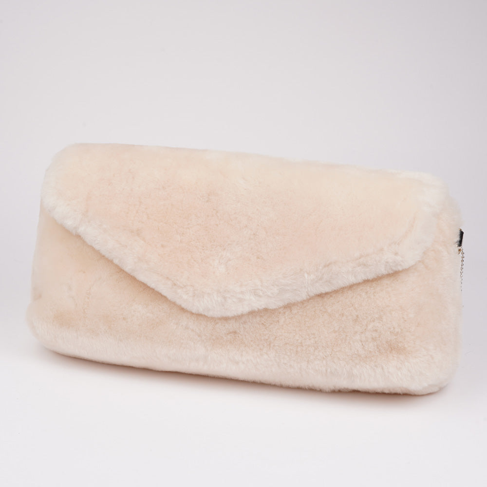 Understated and elegant, this Cona shearling clutch with detachable crossbody strap comes in both black and cream. Cona is perfect for carrying your essentials with you for party or everyday use. Front flap with hidden magnetic fastening Adjustable and detachable wrist strap Adjustable and detachable shoulder strap in leather Shoulder strap 105 cm and 15 mm wide Lining of suede and soft skin