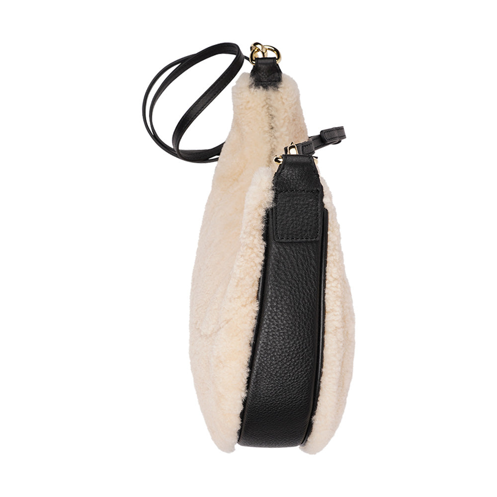 Kangmar is a beautiful shearling handbag which is perfect for carrying your essentials with you, it comes with detachable shoulder strap in skin. Top double zipped closure. Top handle in soft skin with hardware in gold. Adjustable and detachable shoulder strap in leather, 15 mm wide. Satin lining and flat zipped inner pocket Item comes with a branded dust bag. Embossed Lovelies logo inside the bag. Gold-toned hardware Measurements W36 X D5 X H20 cm 100 % Australian shearling