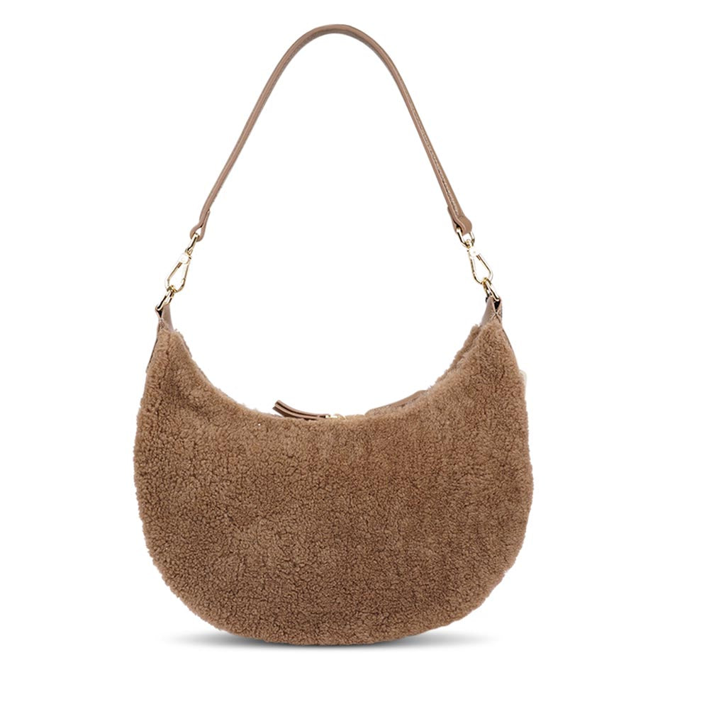 Kangmar is a beautiful shearling handbag which is perfect for carrying your essentials with you, it comes with detachable shoulder strap in skin. Top double zipped closure. Top handle in soft skin with hardware in gold. Adjustable and detachable shoulder strap in leather, 15 mm wide.  Satin lining and flat zipped inner pocket Item comes with a branded dust bag. Embossed Lovelies logo inside the bag.  Gold-toned hardware Measurements W36 X D5 X H20 cm 100 % Australian shearling 