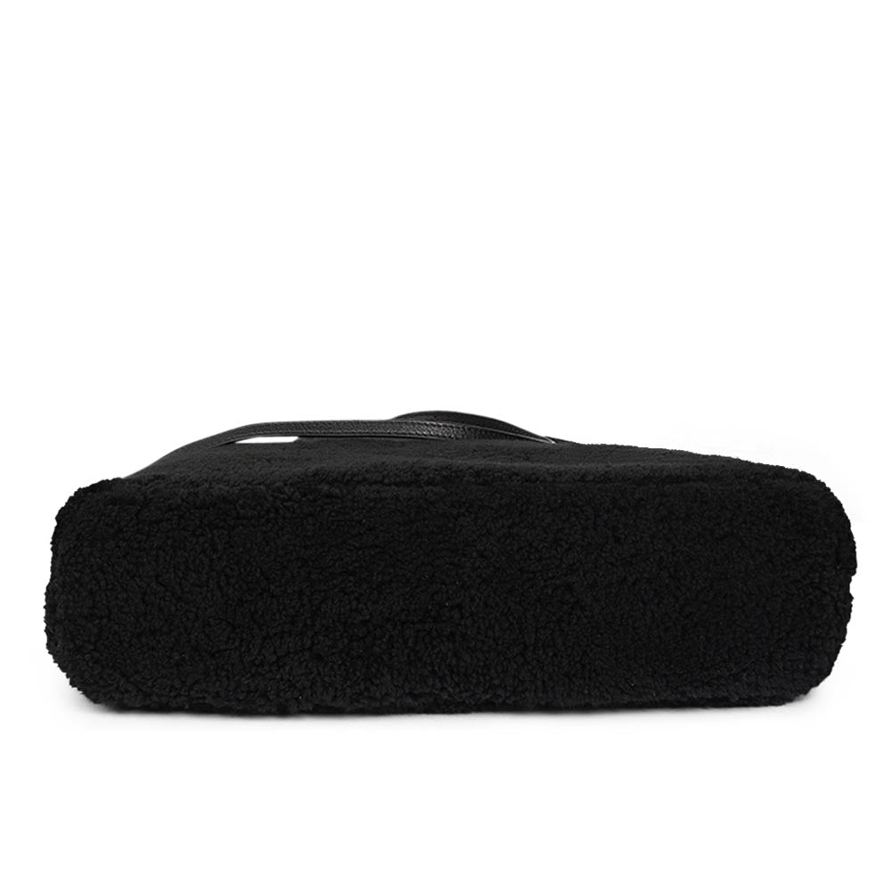 Mainling is a tribute to craftsmanship and the handmade, this large and very soft bag comes in curly shearling and with beautiful leather details. * Top double zipped closure. * Top handle in soft skin with hardware in gold. * Adjustable and detachable shoulder strap in leather, 15 mm wide. * Satin lining and flat zipped inner pocket * Item comes with a branded dust bag. * Embossed Lovelies logo on the front. * Gold-toned hardware * Messurements W40 X D10 X H30 cm * 100 % Australian shearling