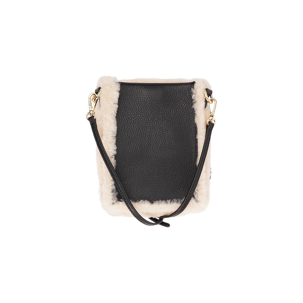 Lovelies studio Tingri is a handy cross shoulder phone bag, hand made from the finest curly shearling from Australia. * Top magnet closing * Adjustable and detachable 8 mm wide shoulder strap in leather * Skin lining and flat inner pocket * Item comes with a branded dust bag. * Embossed Lovelies logo on the front. * Gold-toned hardware * Measurements W12 X D4 X H17 cm * 100 % Australian curly shearling