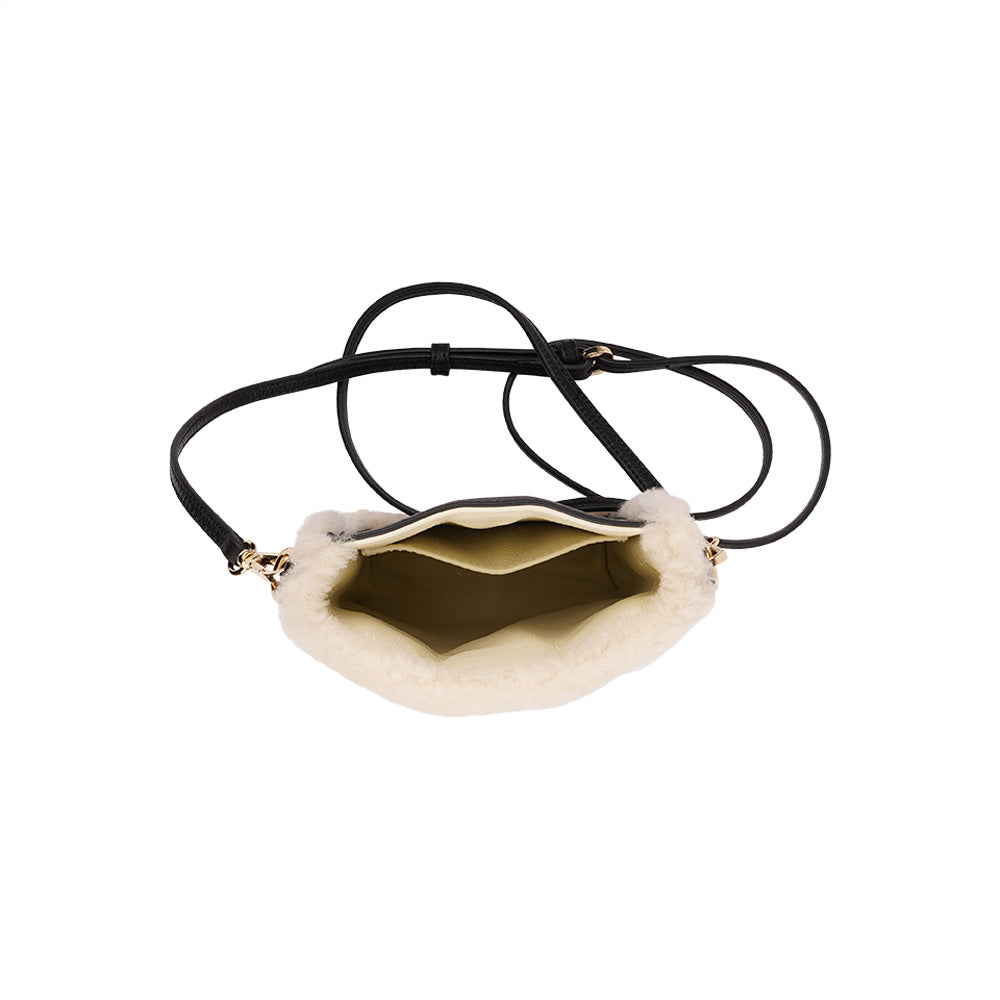 Lovelies studio Tingri is a handy cross shoulder phone bag, hand made from the finest curly shearling from Australia. * Top magnet closing * Adjustable and detachable 8 mm wide shoulder strap in leather * Skin lining and flat inner pocket * Item comes with a branded dust bag. * Embossed Lovelies logo on the front. * Gold-toned hardware * Measurements W12 X D4 X H17 cm * 100 % Australian curly shearling