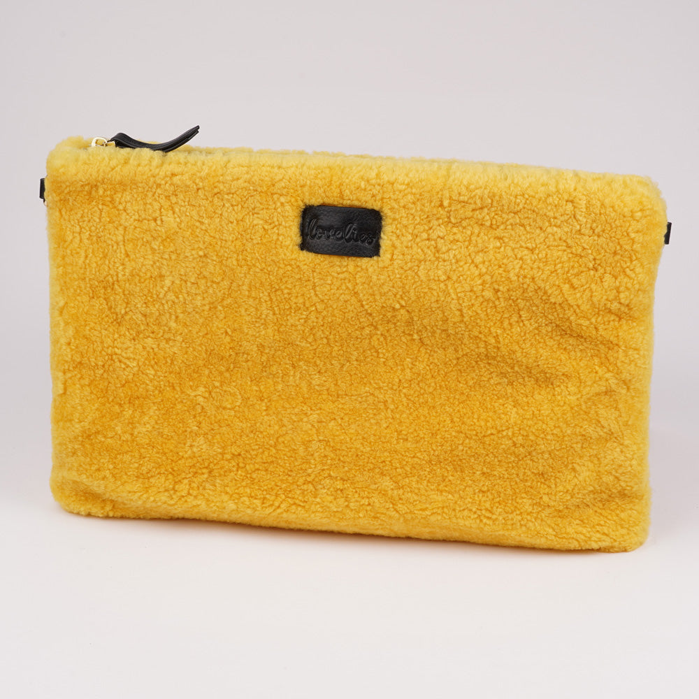 Lovelies Studio Wujii is a large shearling clutch which has room enough for your Ipad and notebooks . Wujii is hand made from the finest curly shearling from Australia.  Top zipped closing   Detachable wrist strap   Satin lining and flat zipped inner pocket   Item comes with a branded dust bag.   Embossed Lovelies logo on the front   Gold-toned hardware   Measurements W34 X D2 X H22 cm   100 % Australian curly shearling