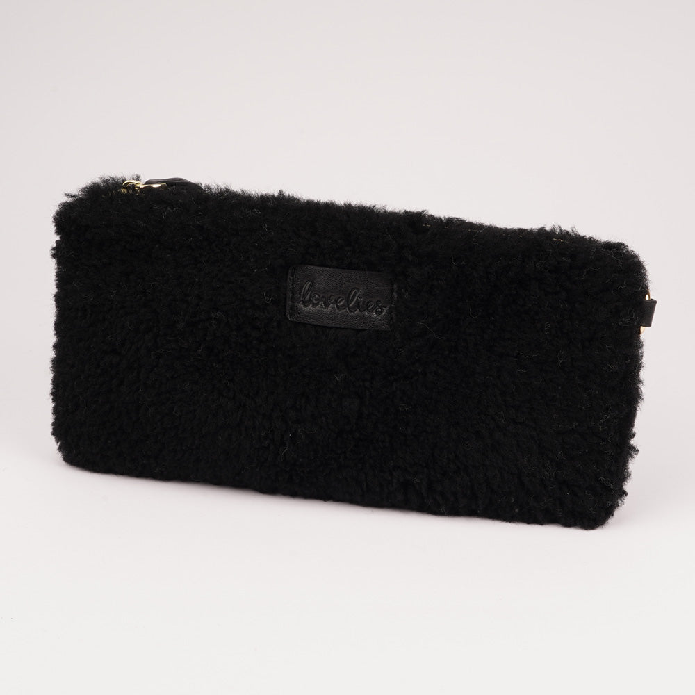 Lovelies Studio _ Wuttu is a mini clutch with a detachable wrist strap and is perfect for carrying your essentials with you. Wuttu is hand made from the finest curly shearling from Australia. Top zipped closing Detachable wrist strap Satin lining and flat zipped inner pocket Item comes with a branded dust bag. Embossed Lovelies logo on the front Gold-toned hardware Measurements W26 X D2 X H12 cm 100 % Australian curly shearling