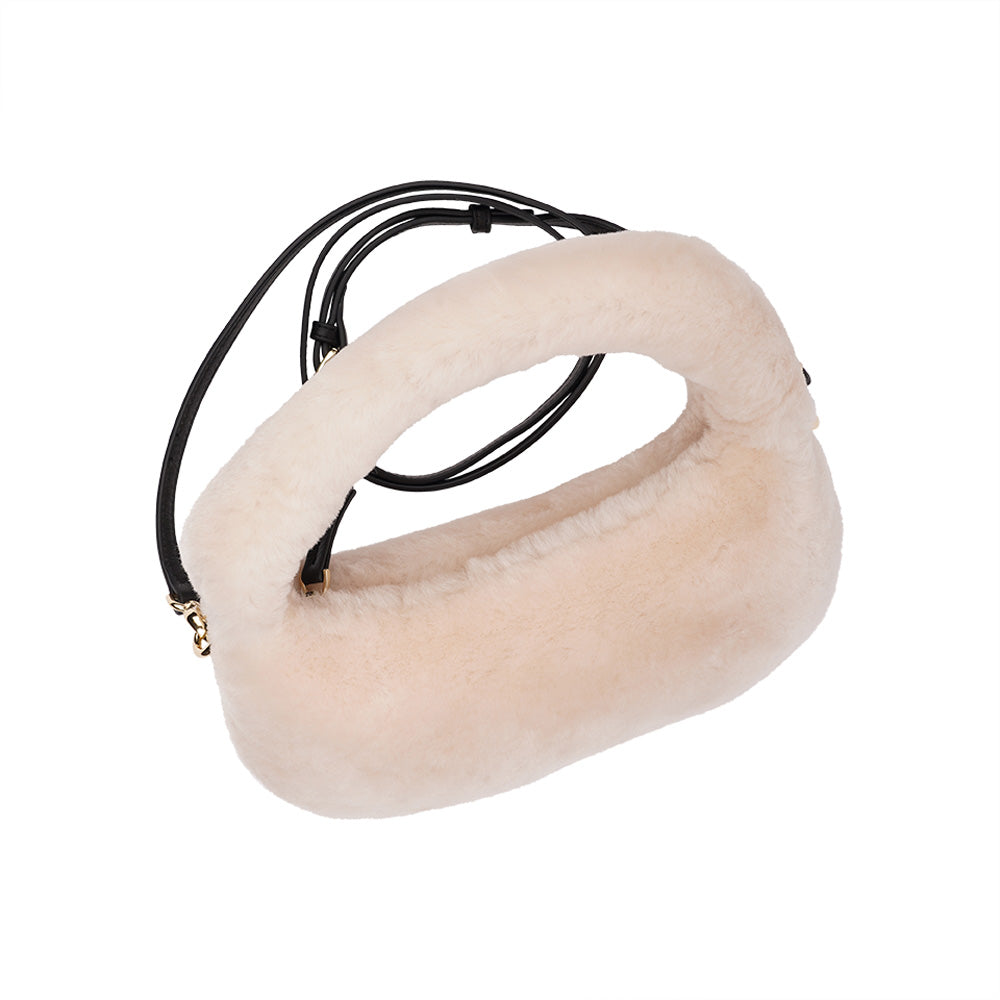 Lovelies Studio - Zhamo is a beautiful small shearling handbag which is perfect for carrying your essentials with you.  * Top handle in thick shearling   * Adjustable and detachable shoulder strap in leather   * Satin lining and flat zipped inner pocket   * Item comes with a branded dust bag.   * Gold-toned hardware   * Messurements W26 X D6 X H24 cm   * 100 % Australian shearling