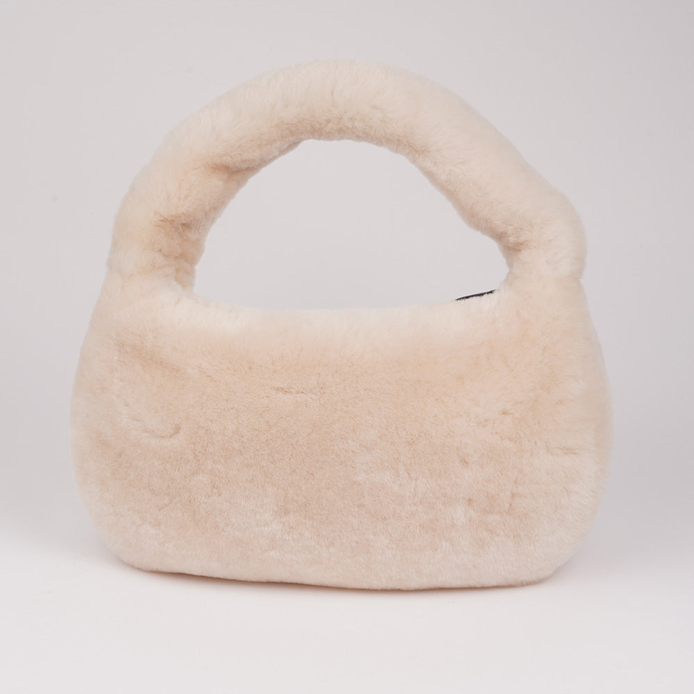 Lovelies Studio - Zhamo is a beautiful small shearling handbag which is perfect for carrying your essentials with you.  * Top handle in thick shearling   * Adjustable and detachable shoulder strap in leather   * Satin lining and flat zipped inner pocket   * Item comes with a branded dust bag.   * Gold-toned hardware   * Messurements W26 X D6 X H24 cm   * 100 % Australian shearling