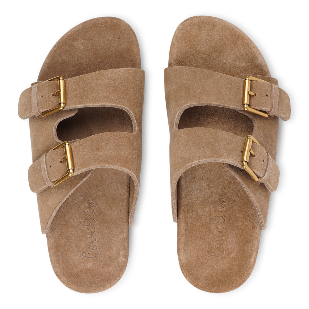 Lovelies Studio - Denmark - Effortlessly laid-back with a touch of understated luxury, these suede sandals are designed for all-day comfort and timeless appeal. Crafted from rich, soft suede, they feature two wide straps with adjustable gold-tone buckles for a customizable fit. The contoured footbed offers light support, while the flexible sole ensures ease of movement from indoors to out.
Perfect for casual days, warm getaways, or everyday lounging in style.