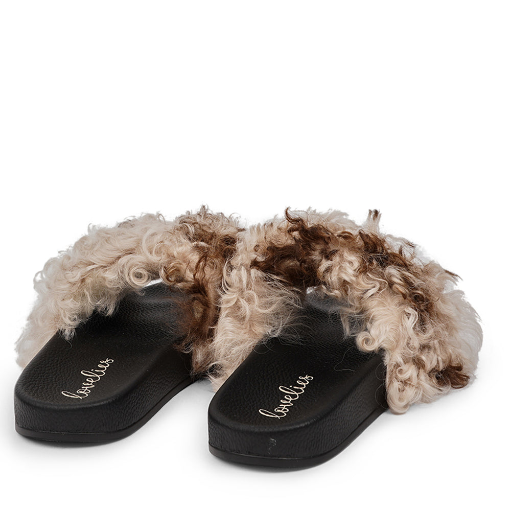 The Lennox Slide - a harmonious blend of comfort and elegance. These slides offer a touch of luxury for your feet, featuring naturally curly Tuscany shearling sourced from Australia.  The premium rubber sole ensures durability and excellent grip, making them versatile for indoor and outdoor wear. The shearling lining provides a cozy and comfortable experience, perfect for any season.