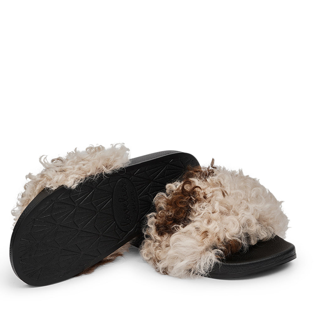 The Lennox Slide - a harmonious blend of comfort and elegance. These slides offer a touch of luxury for your feet, featuring naturally curly Tuscany shearling sourced from Australia.  The premium rubber sole ensures durability and excellent grip, making them versatile for indoor and outdoor wear. The shearling lining provides a cozy and comfortable experience, perfect for any season.