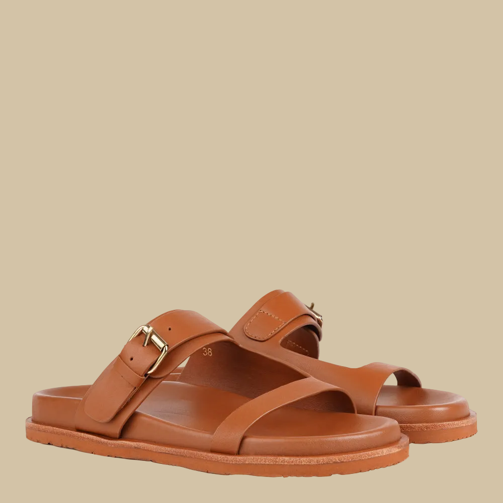 Lovelies - Marina - a beautifully handcrafted leather sandal that blends feminine elegance with everyday comfort. Designed with a single adjustable strap, it offers a secure, personalized fit that moves effortlessly with you throughout the day.

Crafted from vegetable-tanned buffalo leather, the soft yet durable straps are made to age beautifully over time. Finished with a discreet rubber grip, Marina provides stability and ease - perfect for both relaxed daytime wear and more refined evening looks.