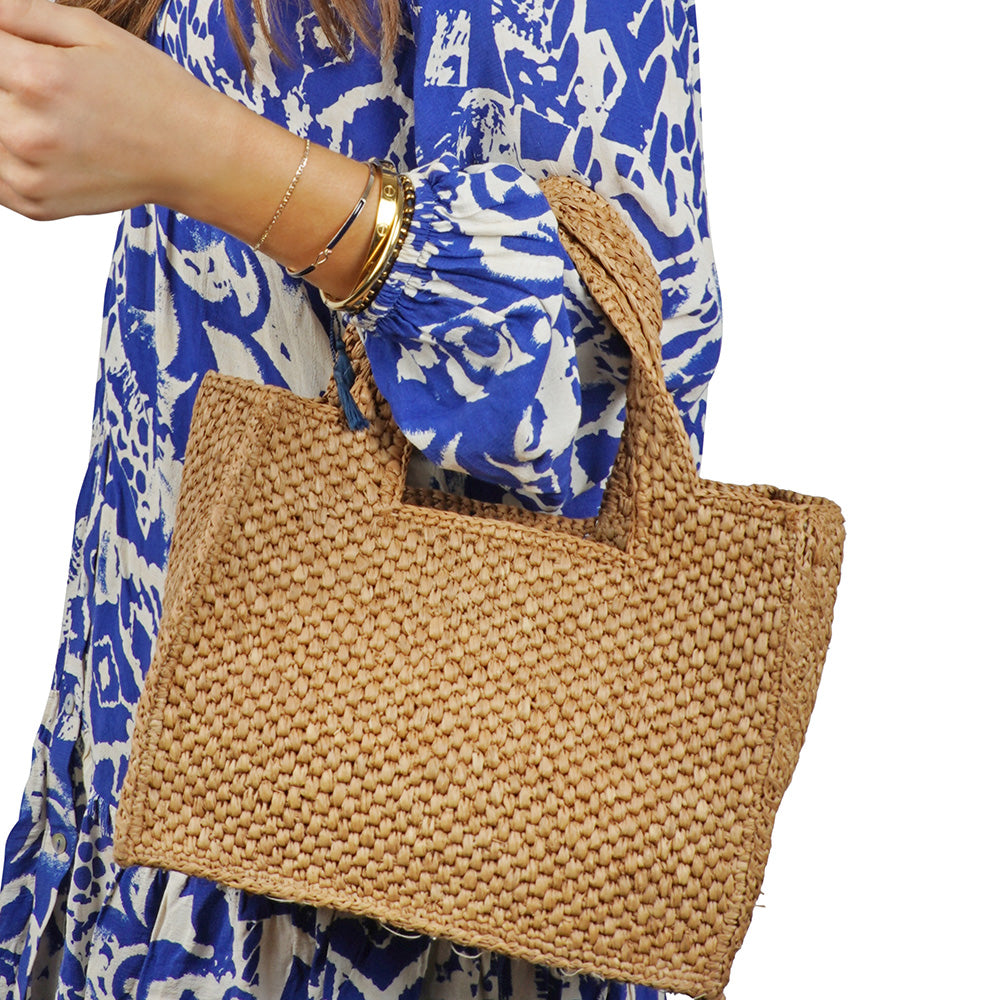 Lovelies - Effortlessly chic and naturally elegant, the Rivabella bag is your go-to accessory for sun-soaked days and breezy evenings. Handwoven from 100% raffia by skilled artisans in Madagascar, this compact yet spacious bag blends timeless craftsmanship with modern simplicity.

The raffia’s rich texture and earthy tone add a relaxed sophistication to any look—perfect for everything from a city stroll to a summer soirée. Lightweight yet durable, Rivabella is designed to accompany you all day with ease. Th