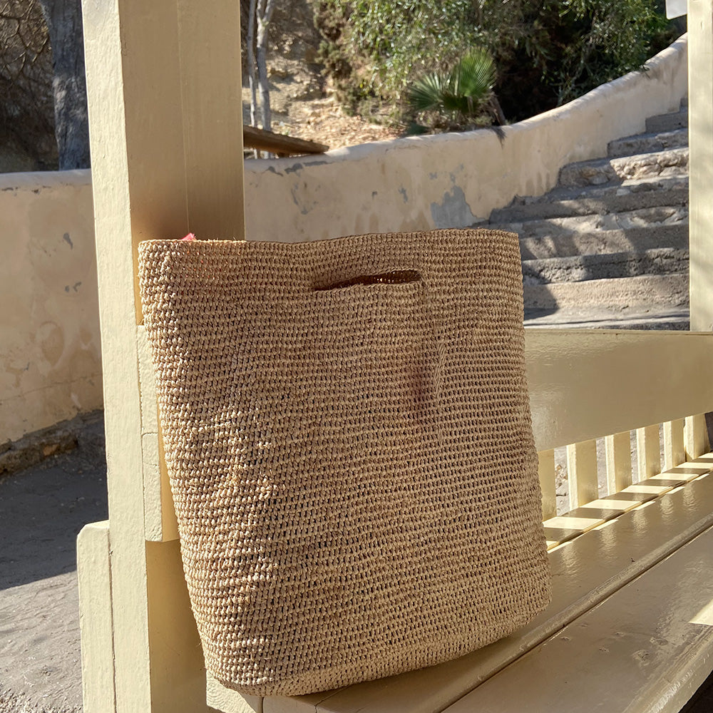 Taccu, the charming tote bag fashioned from luxurious raffia sourced from Madagascar.  Tailored for your everyday adventures, this tote boasts a spacious main compartment to accommodate all your necessities while you're on the move.  Raffia, derived from the resilient leaves of the palm tree, is celebrated for its versatility and eco-conscious qualities, making it a sought-after material in the realm of fashion accessories.