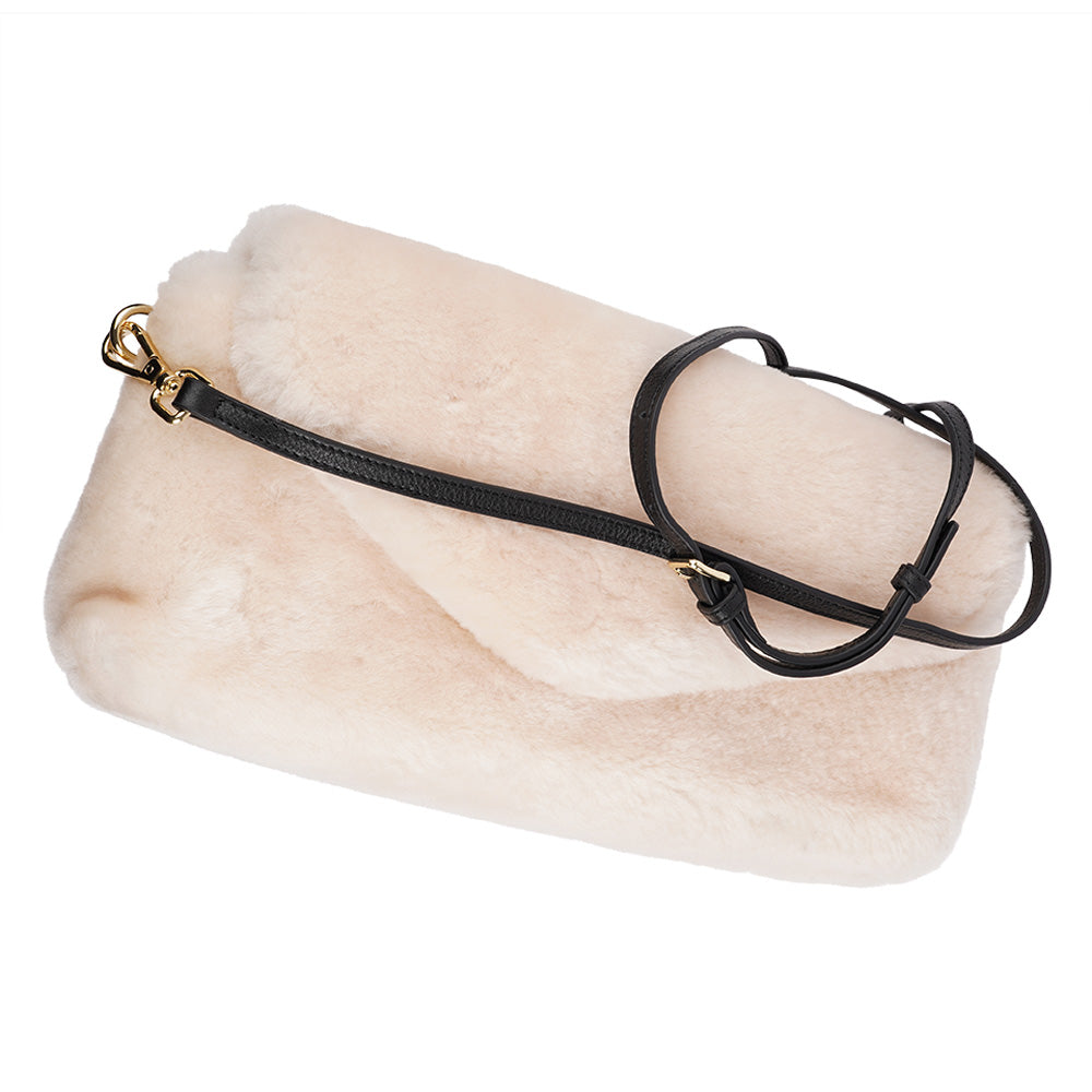 Understated and elegant, this Cona shearling clutch with detachable crossbody strap comes in both black and cream. Cona is perfect for carrying your essentials with you for party or everyday use.  Front flap with hidden magnetic fastening  Adjustable and detachable wrist strap  Adjustable and detachable shoulder strap in leather  Shoulder strap 105 cm and 15 mm wide  Lining of suede and soft skin