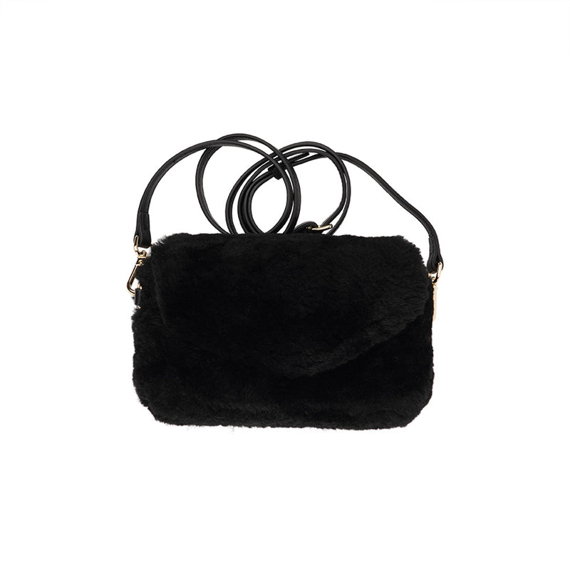 Lovelies Studio Understated and elegant, the little sister Corso shearling clutch with detachable crossbody strap comes in both black and cream. Corso is perfect for carrying your essentials with you for party or everyday use. Front flap with hidden magnetic fastening.   Adjustable and detachable wrist strap. Adjustable and detachable shoulder strap in leather. Shoulder strap 105 cm and 15 mm wide. Lining of suede and soft skin.  Flat zipped inner pocket.  Embossed Lovelies logo inside the bag 