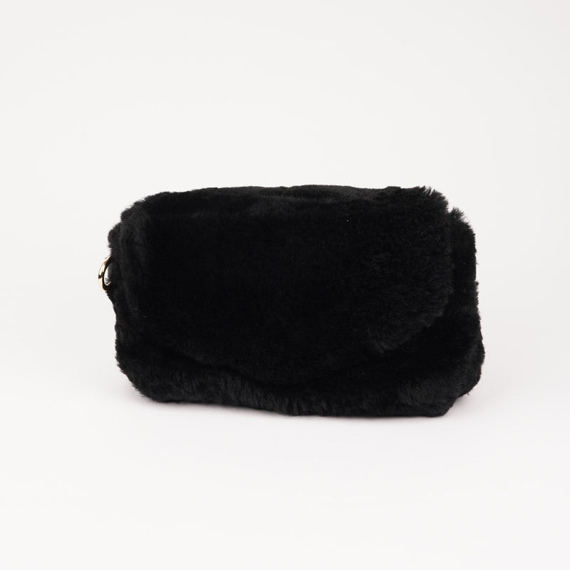 Understated and elegant, the little sister Corso shearling clutch with detachable crossbody strap comes in both black and cream. Corso is perfect for carrying your essentials with you for party or everyday use.   * Front flap with hidden magnetic fastening   * Adjustable and detachable wrist strap   * Adjustable and detachable shoulder strap in leather * Shoulder strap 105 cm and 15 mm wide   * Lining of suede and soft skin.   * Flat zipped inner pocket   * Embossed Lovelies logo inside the bag 