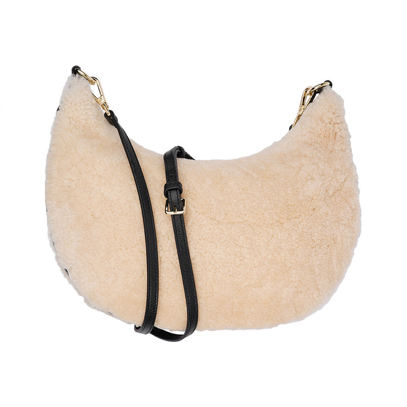 Kangmar is a beautiful shearling handbag which is perfect for carrying your essentials with you, it comes with detachable shoulder strap in skin. Top double zipped closure. Top handle in soft skin with hardware in gold. Adjustable and detachable shoulder strap in leather, 15 mm wide.  Satin lining and flat zipped inner pocket Item comes with a branded dust bag. Embossed Lovelies logo inside the bag.  Gold-toned hardware Measurements W36 X D5 X H20 cm 100 % Australian shearling 