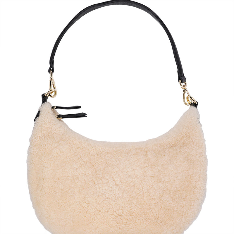 Kangmar is a beautiful shearling handbag which is perfect for carrying your essentials with you, it comes with detachable shoulder strap in skin. Top double zipped closure. Top handle in soft skin with hardware in gold. Adjustable and detachable shoulder strap in leather, 15 mm wide.  Satin lining and flat zipped inner pocket Item comes with a branded dust bag. Embossed Lovelies logo inside the bag.  Gold-toned hardware Measurements W36 X D5 X H20 cm 100 % Australian shearling 