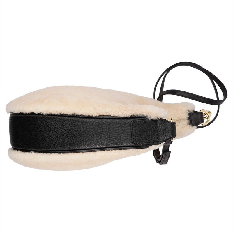 Kangmar is a beautiful shearling handbag which is perfect for carrying your essentials with you, it comes with detachable shoulder strap in skin. Top double zipped closure. Top handle in soft skin with hardware in gold. Adjustable and detachable shoulder strap in leather, 15 mm wide.  Satin lining and flat zipped inner pocket Item comes with a branded dust bag. Embossed Lovelies logo inside the bag.  Gold-toned hardware Measurements W36 X D5 X H20 cm 100 % Australian shearling 