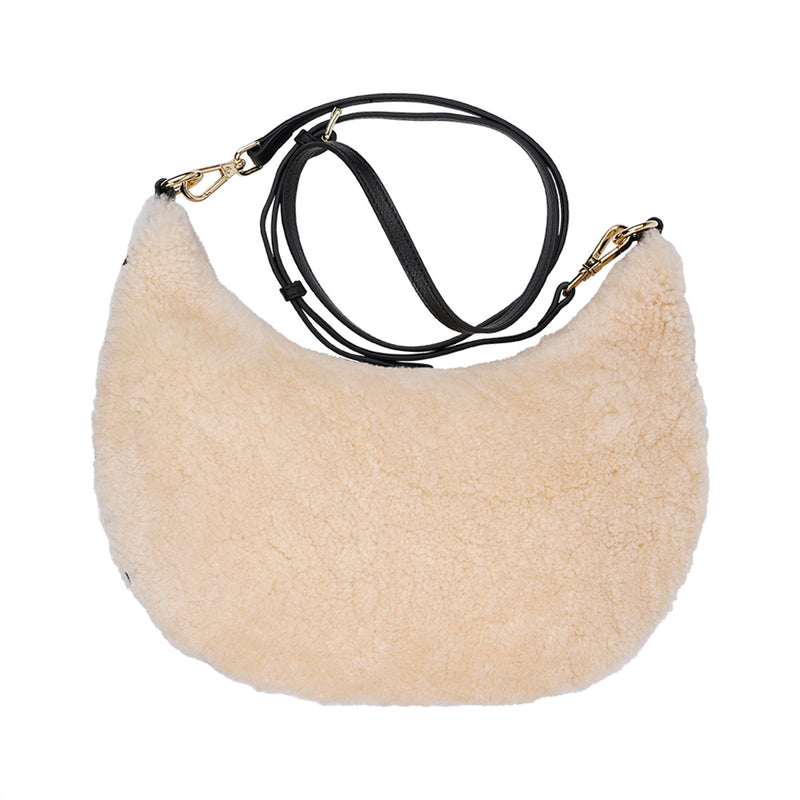 Kangmar is a beautiful shearling handbag which is perfect for carrying your essentials with you, it comes with detachable shoulder strap in skin. Top double zipped closure. Top handle in soft skin with hardware in gold. Adjustable and detachable shoulder strap in leather, 15 mm wide.  Satin lining and flat zipped inner pocket Item comes with a branded dust bag. Embossed Lovelies logo inside the bag.  Gold-toned hardware Measurements W36 X D5 X H20 cm 100 % Australian shearling 