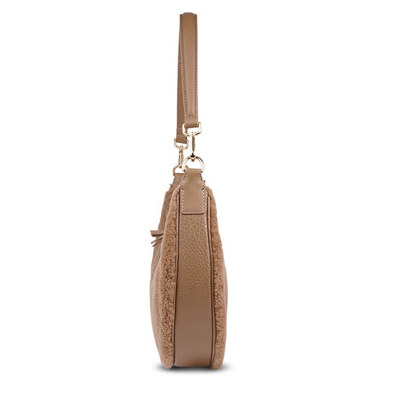 Kangmar is a beautiful shearling handbag which is perfect for carrying your essentials with you, it comes with detachable shoulder strap in skin. Top double zipped closure. Top handle in soft skin with hardware in gold. Adjustable and detachable shoulder strap in leather, 15 mm wide.  Satin lining and flat zipped inner pocket Item comes with a branded dust bag. Embossed Lovelies logo inside the bag.  Gold-toned hardware Measurements W36 X D5 X H20 cm 100 % Australian shearling 