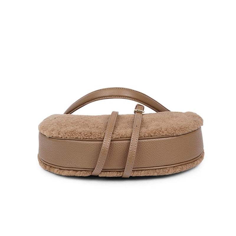 Kangmar is a beautiful shearling handbag which is perfect for carrying your essentials with you, it comes with detachable shoulder strap in skin. Top double zipped closure. Top handle in soft skin with hardware in gold. Adjustable and detachable shoulder strap in leather, 15 mm wide.  Satin lining and flat zipped inner pocket Item comes with a branded dust bag. Embossed Lovelies logo inside the bag.  Gold-toned hardware Measurements W36 X D5 X H20 cm 100 % Australian shearling 