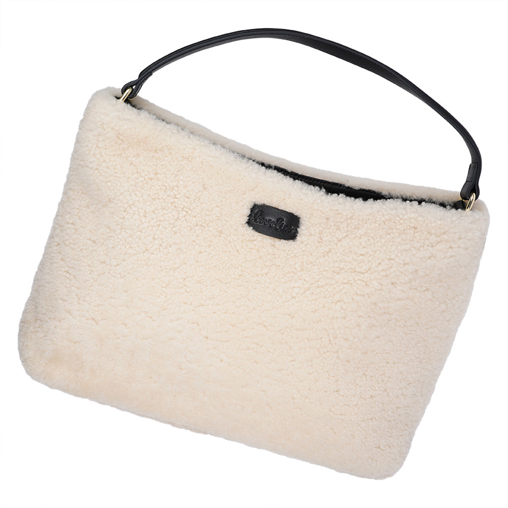 Mainling is a tribute to craftsmanship and the handmade, this large and very soft bag comes in curly shearling and with beautiful leather details. * Top double zipped closure. * Top handle in soft skin with hardware in gold. * Adjustable and detachable shoulder strap in leather, 15 mm wide. * Satin lining and flat zipped inner pocket * Item comes with a branded dust bag. * Embossed Lovelies logo on the front. * Gold-toned hardware * Messurements W40 X D10 X H30 cm * 100 % Australian shearling