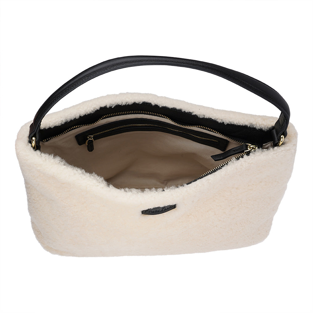 Mainling is a tribute to craftsmanship and the handmade, this large and very soft bag comes in curly shearling and with beautiful leather details. * Top double zipped closure. * Top handle in soft skin with hardware in gold. * Adjustable and detachable shoulder strap in leather, 15 mm wide. * Satin lining and flat zipped inner pocket * Item comes with a branded dust bag. * Embossed Lovelies logo on the front. * Gold-toned hardware * Messurements W40 X D10 X H30 cm * 100 % Australian shearling