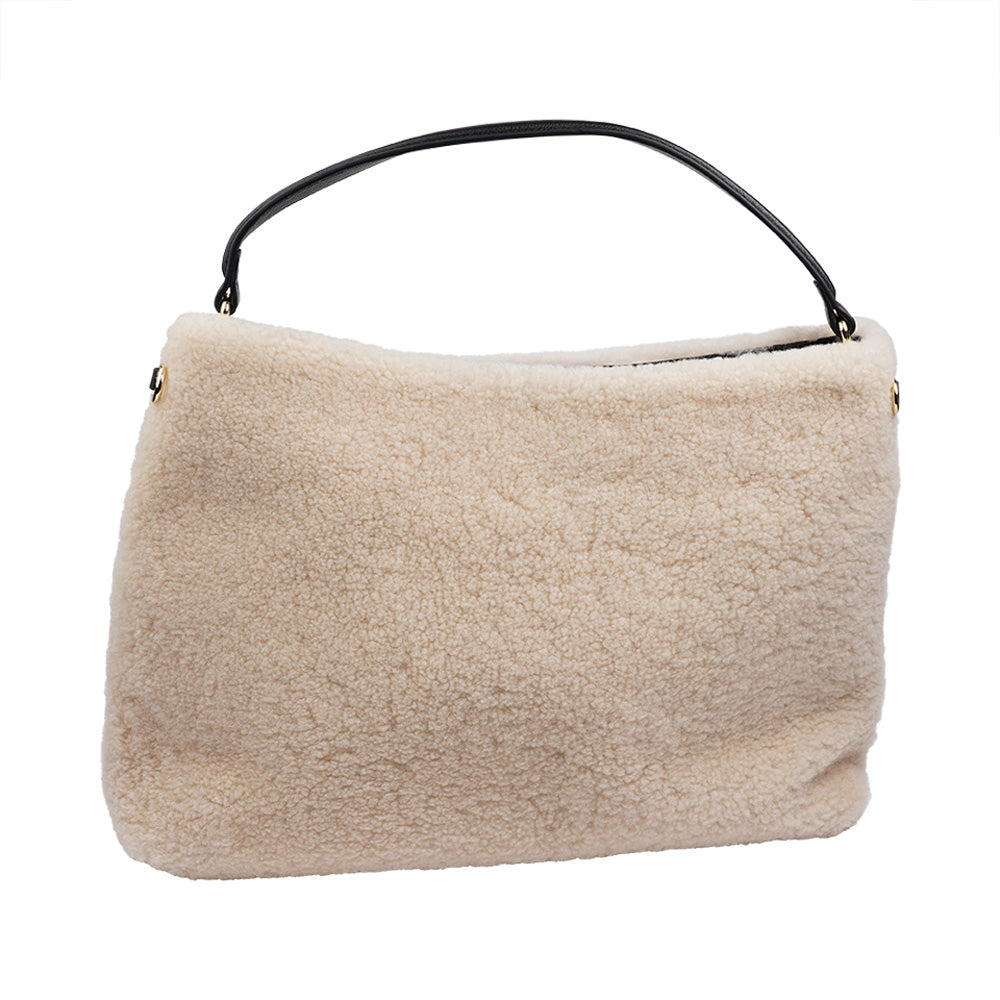 Mainling is a tribute to craftsmanship and the handmade, this large and very soft bag comes in curly shearling and with beautiful leather details. * Top double zipped closure. * Top handle in soft skin with hardware in gold. * Adjustable and detachable shoulder strap in leather, 15 mm wide. * Satin lining and flat zipped inner pocket * Item comes with a branded dust bag. * Embossed Lovelies logo on the front. * Gold-toned hardware * Messurements W40 X D10 X H30 cm * 100 % Australian shearling