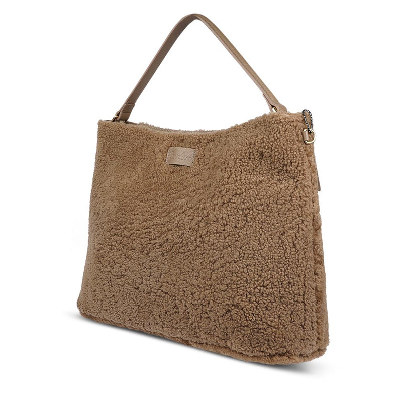 Mainling is a tribute to craftsmanship and the handmade, this large and very soft bag comes in curly shearling and with beautiful leather details. * Top double zipped closure. * Top handle in soft skin with hardware in gold. * Adjustable and detachable shoulder strap in leather, 15 mm wide. * Satin lining and flat zipped inner pocket * Item comes with a branded dust bag. * Embossed Lovelies logo on the front. * Gold-toned hardware * Messurements W40 X D10 X H30 cm * 100 % Australian shearling